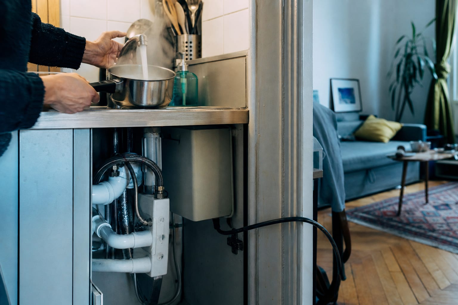 Mains utilisant un robinet relié à un chauffe-eau instantané sous évier.