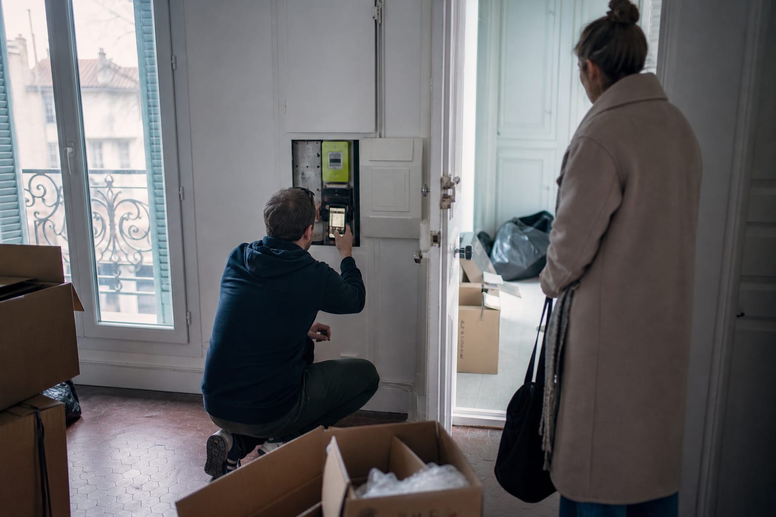 Deux locataires encadrent le relevé du compteur dans un appartement vide.