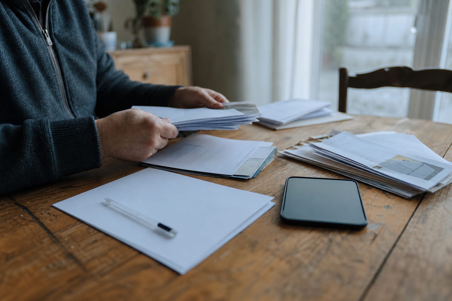Mains classant des preuves de litige énergétique sur une table.